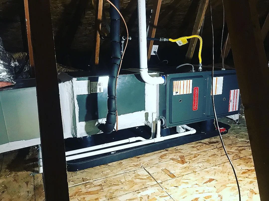 Dual HVAC units with white ductwork, yellow gas line, and electrical connections in basement