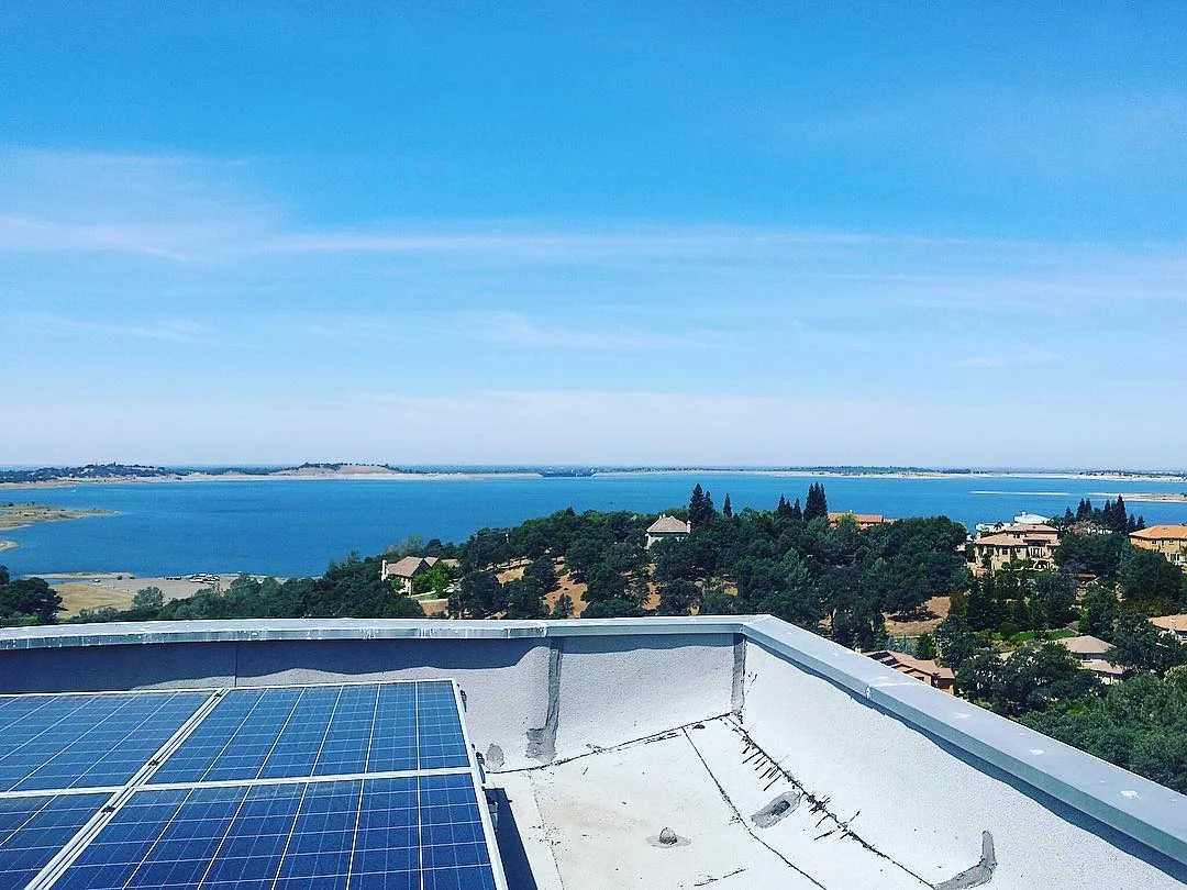 Rooftop HVAC equipment and solar panels on residential building with water view