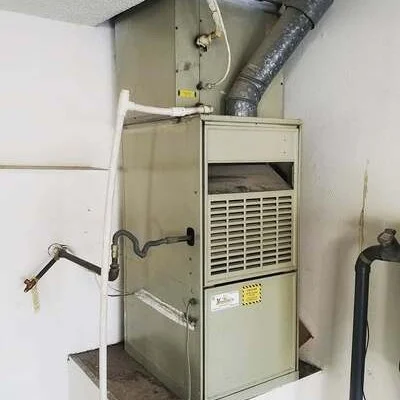 Installed furnace unit with connected ductwork, insulation, and condensate drain line in mechanical room