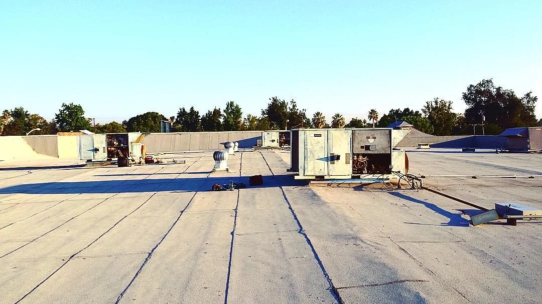 Commercial rooftop with multiple HVAC units and blue-marked ductwork layout lines
